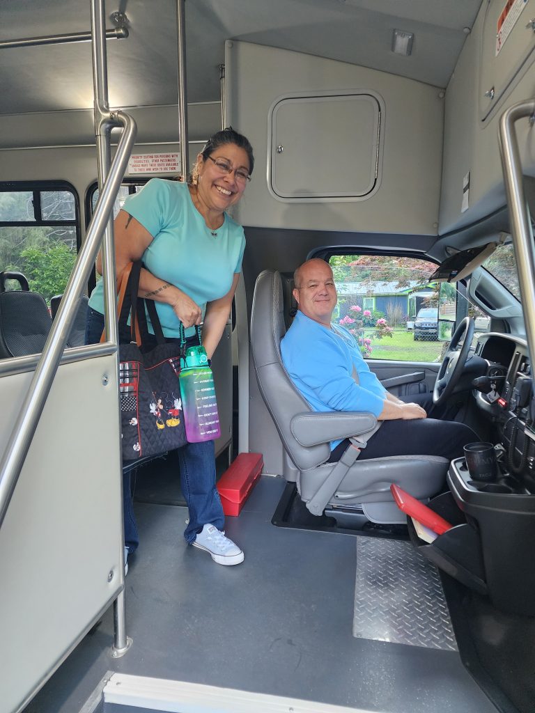 Person standing on bus next to bus driver