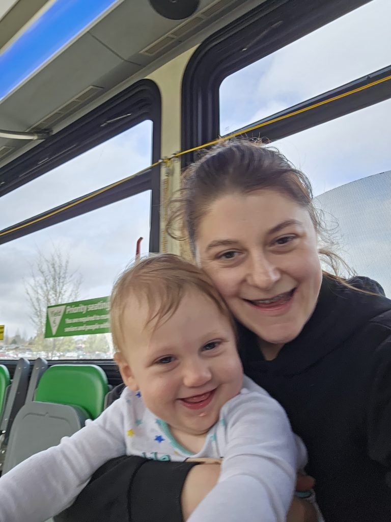 A woman and a baby riding public transit together.