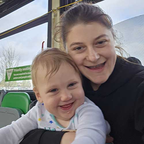 A woman and a baby riding public transit together.